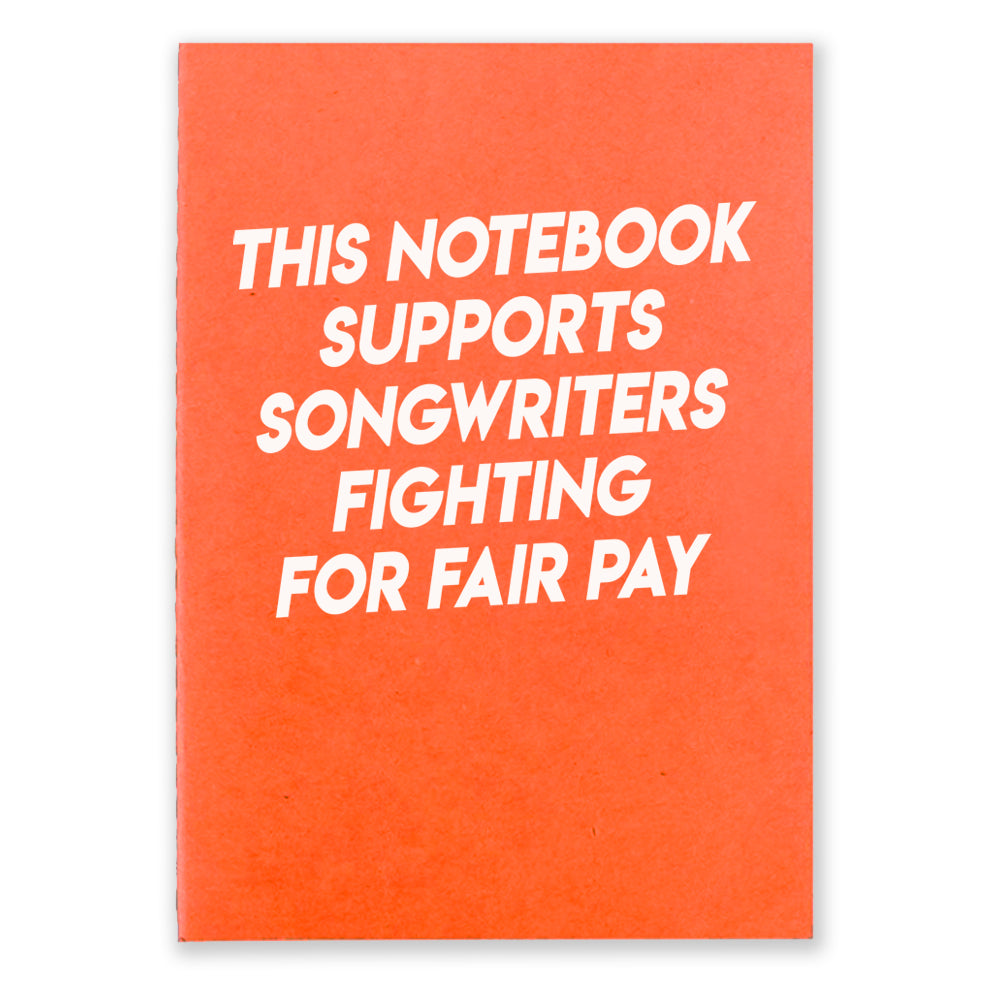 1 orange notebook that says "This Notebook supports songwriters fighting for fair pay" in white texton the front