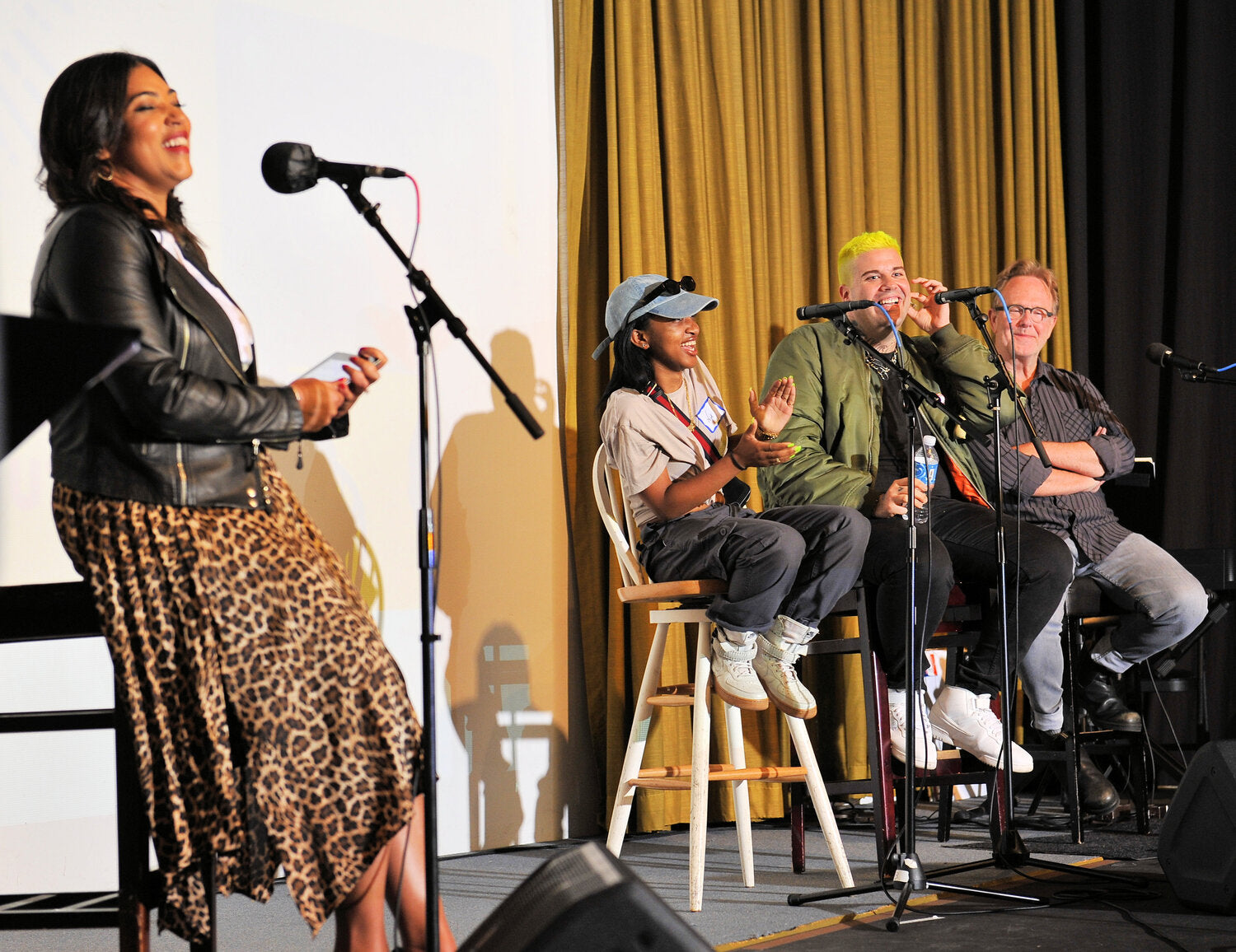 Four people on stage with microphones