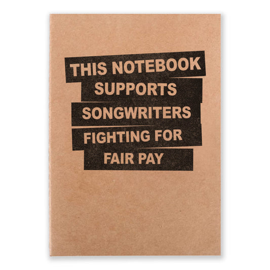 A notebook that say "This Notebook Supports Songwriters Fighting For Equal Pay" on the front