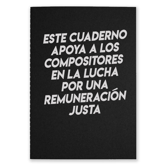 A black notebook that says "Este Cuaderno Apoya A Los Compistores En La Lucha Por Una Remuneracion Justa" on the front with white text