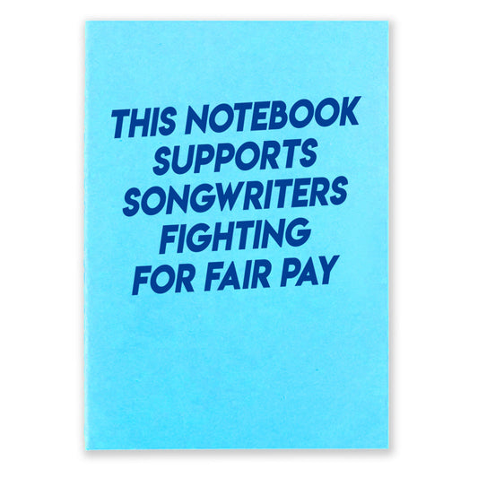 1 light blue notebook that says "This Notebook supports songwriters fighting for fair pay" in dark blue text on the front