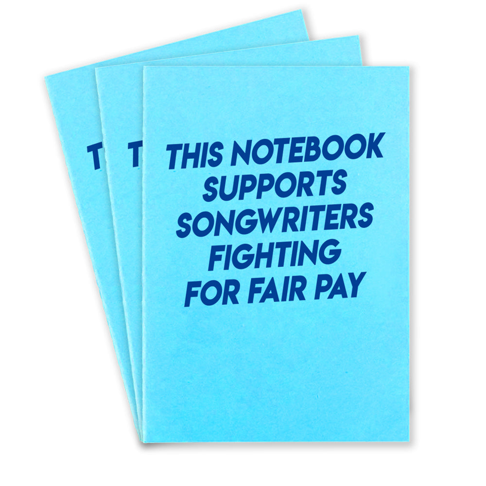 3 light blue notebooks that says "This Notebook supports songwriters fighting for fair pay" in dark blue text on the front