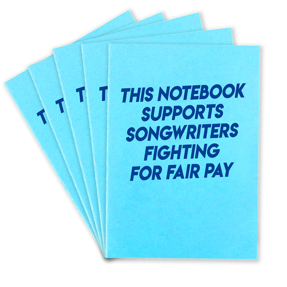 5 light blue notebooks that says "This Notebook supports songwriters fighting for fair pay" in dark blue text on the front