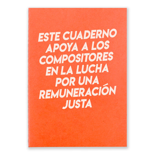 An orange notebook that says "Este Cuaderno Apoya A Los Compistores En La Lucha Por Una Remuneracion Justa" on the front