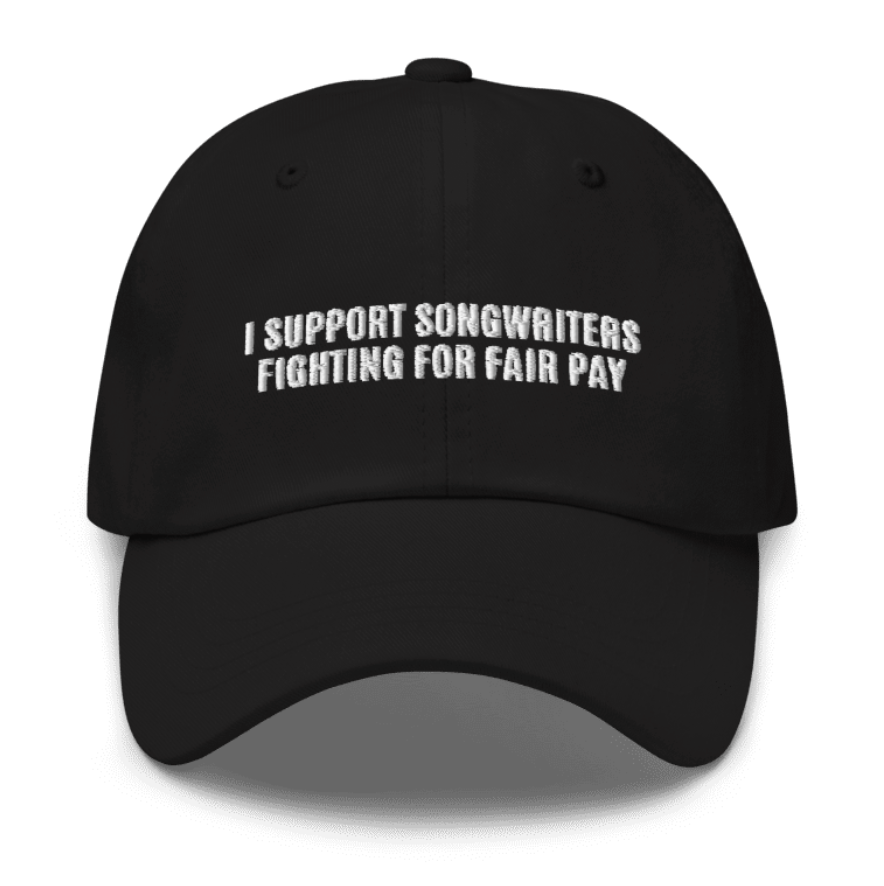 A black hat with white text that says "I support songwriters fighting for fair pay"